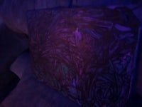 a purple painting on a couch in the dark