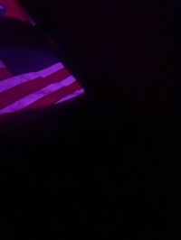 a person is sitting in a dark room with a purple flag